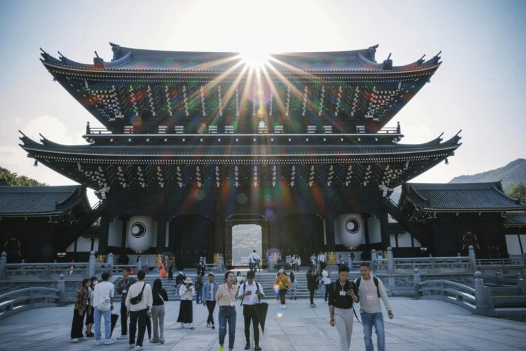 Visitors enjoying a sunny day at a traditional Japanese temple, showcasing stunning architecture.